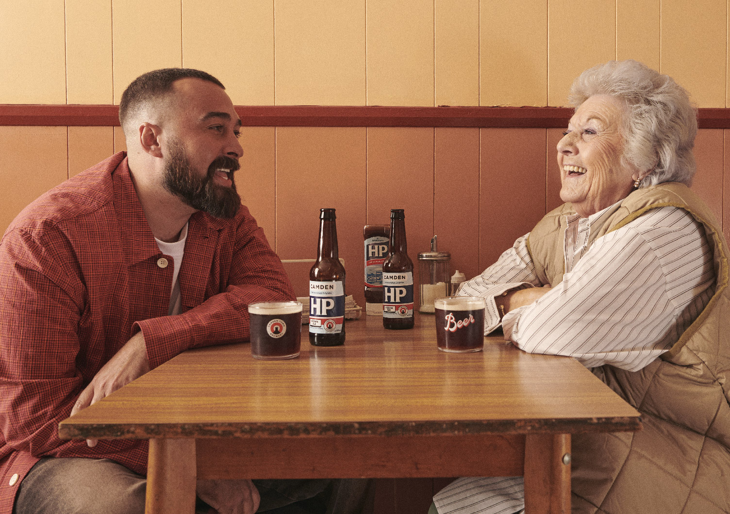 Two people in a café with Camden HP beer and bottles of HP Sauce