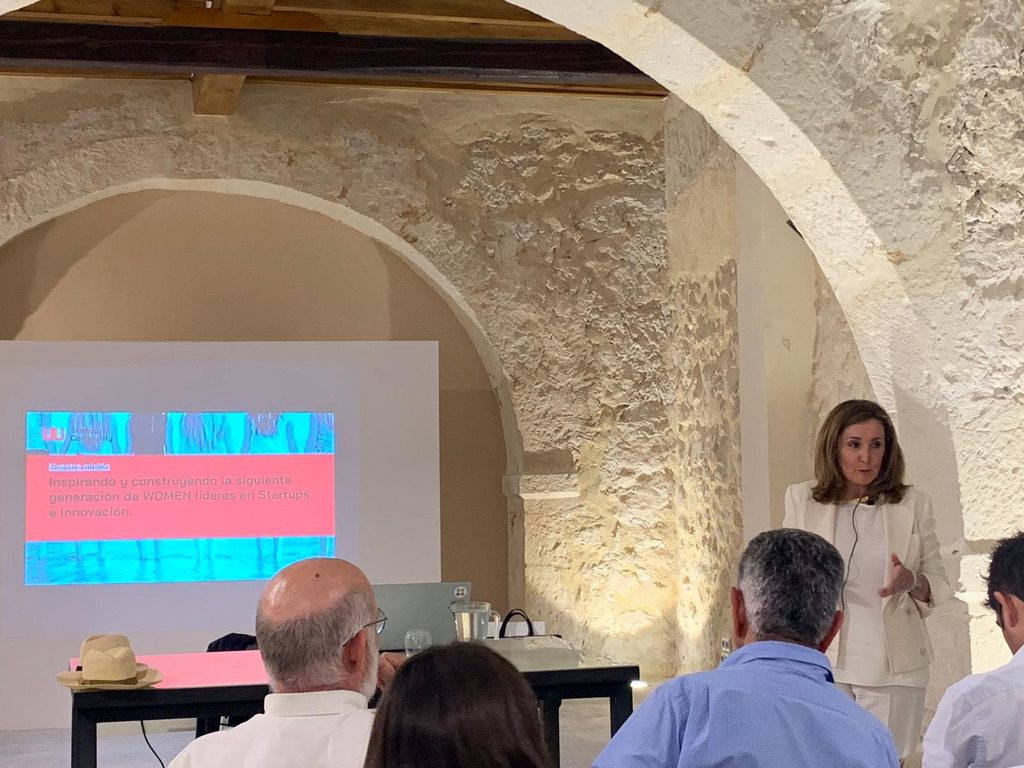 Teresa Alarcos presenting W Startup Community to an audience beneath the stone arches at Torre Juana