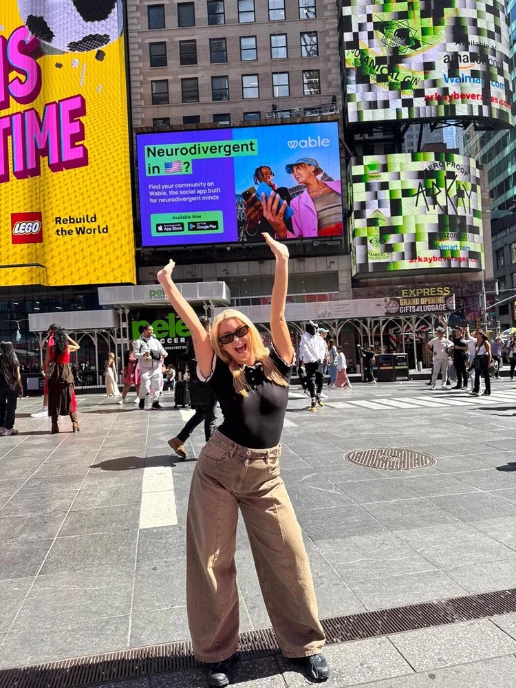 Holly Fowler in Times Square in front of a Wable billboard