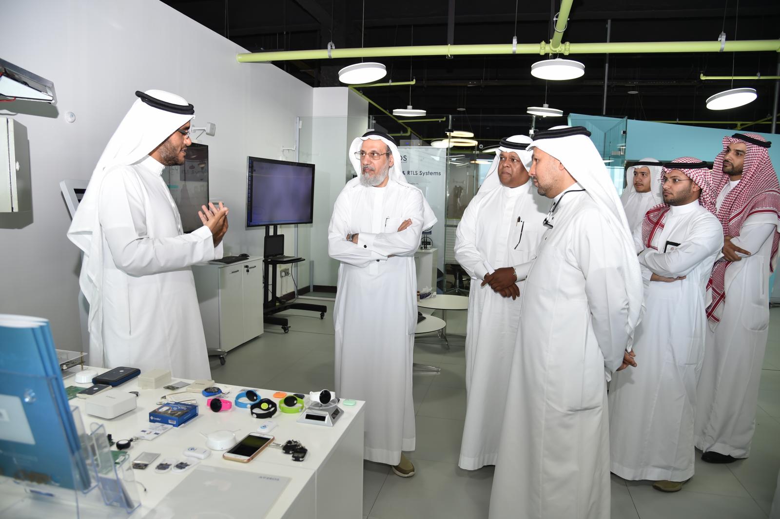 Visitors listen to a demonstration beside a table of electronic devices at Wadi Makkah’s startup center in 2018