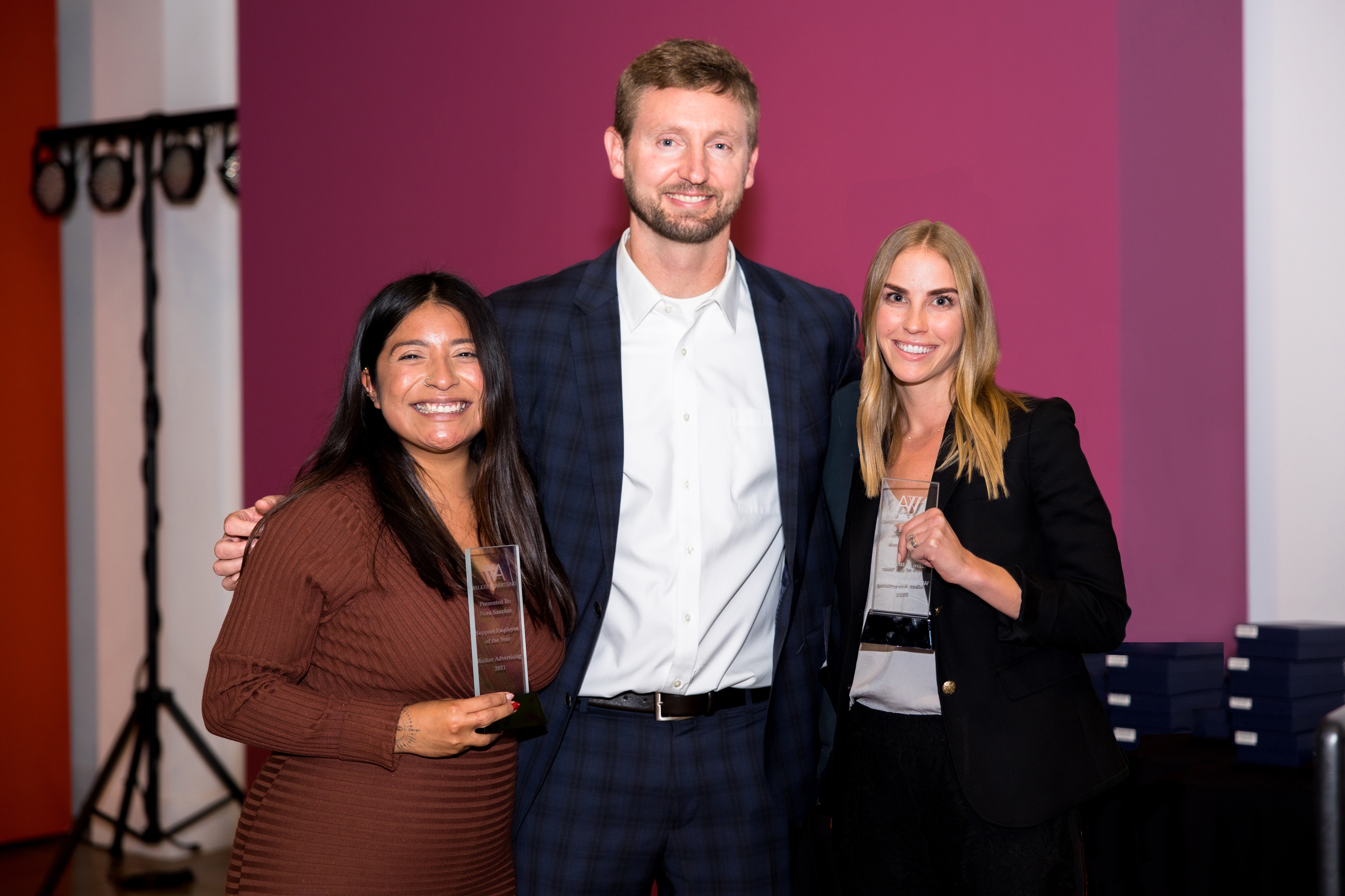 Walker Advertising CEO Ben Henderson with two employees holding awards