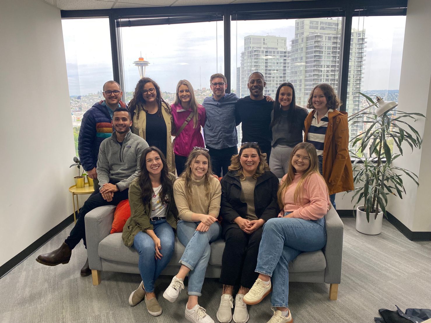 Walker Sands team members gathered in the Seattle office with the Space Needle visible through the windows