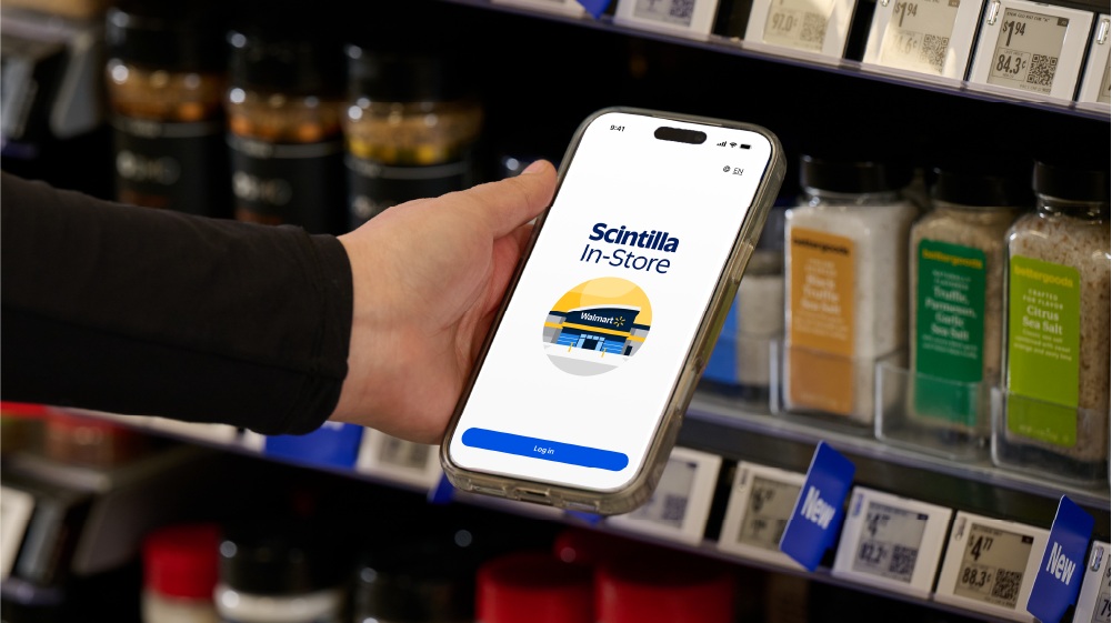 A hand holding the Scintilla In-Store app in a Walmart grocery aisle