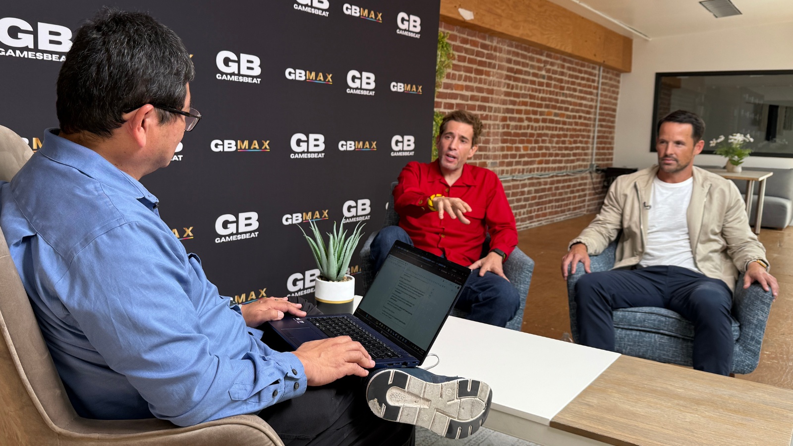 Dean Takahashi interviews Javier Ferreira, seated in red, and Walter Driver, seated at right, during GDC week.