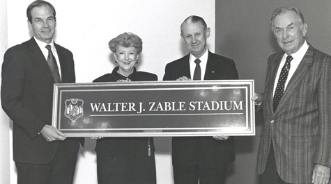 Paul Verkuil, Betty Zable, Hays Watkins and Walter Zable hold the Walter J. Zable Stadium sign at the 1990 dedication.