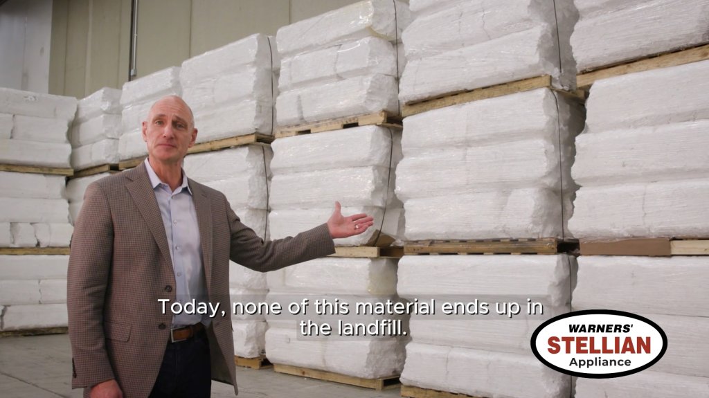 A Warners' Stellian executive standing in front of baled foam packaging in a warehouse