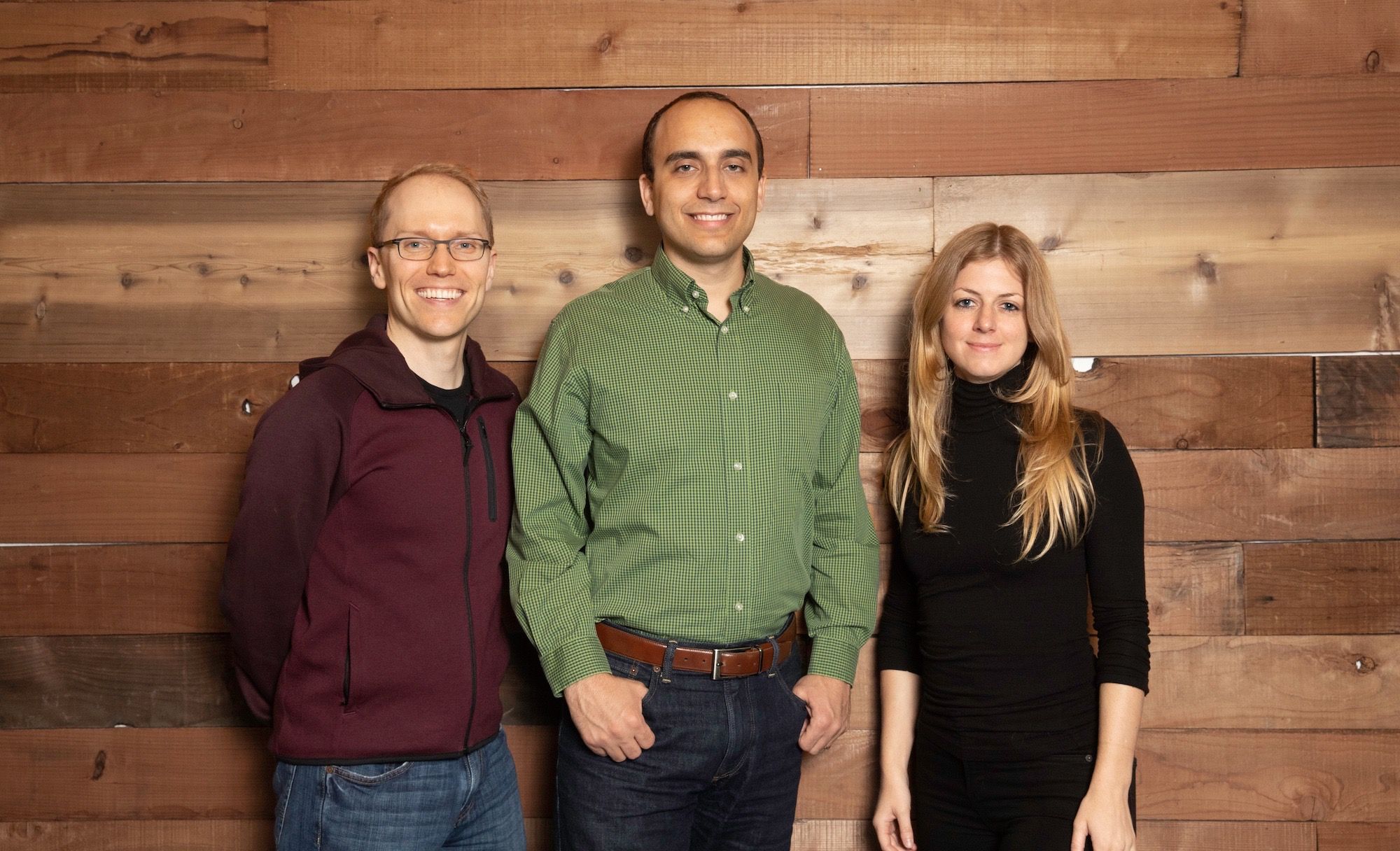 Pilot co-founders Jeff Arnold, Waseem Daher, and Jessica McKellar standing together in front of a wooden wall.