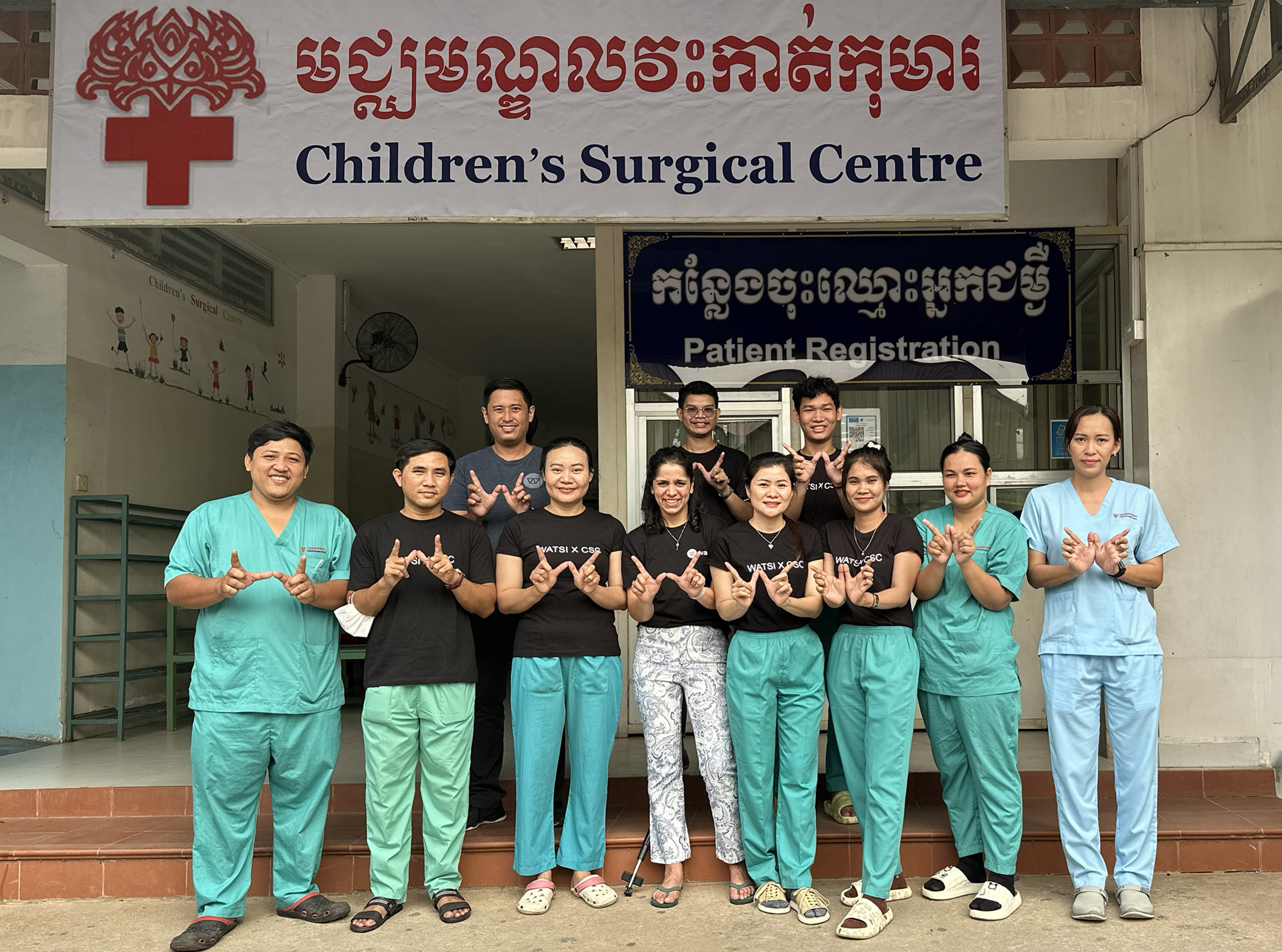 Staff of Children's Surgical Centre in Cambodia standing outside the hospital