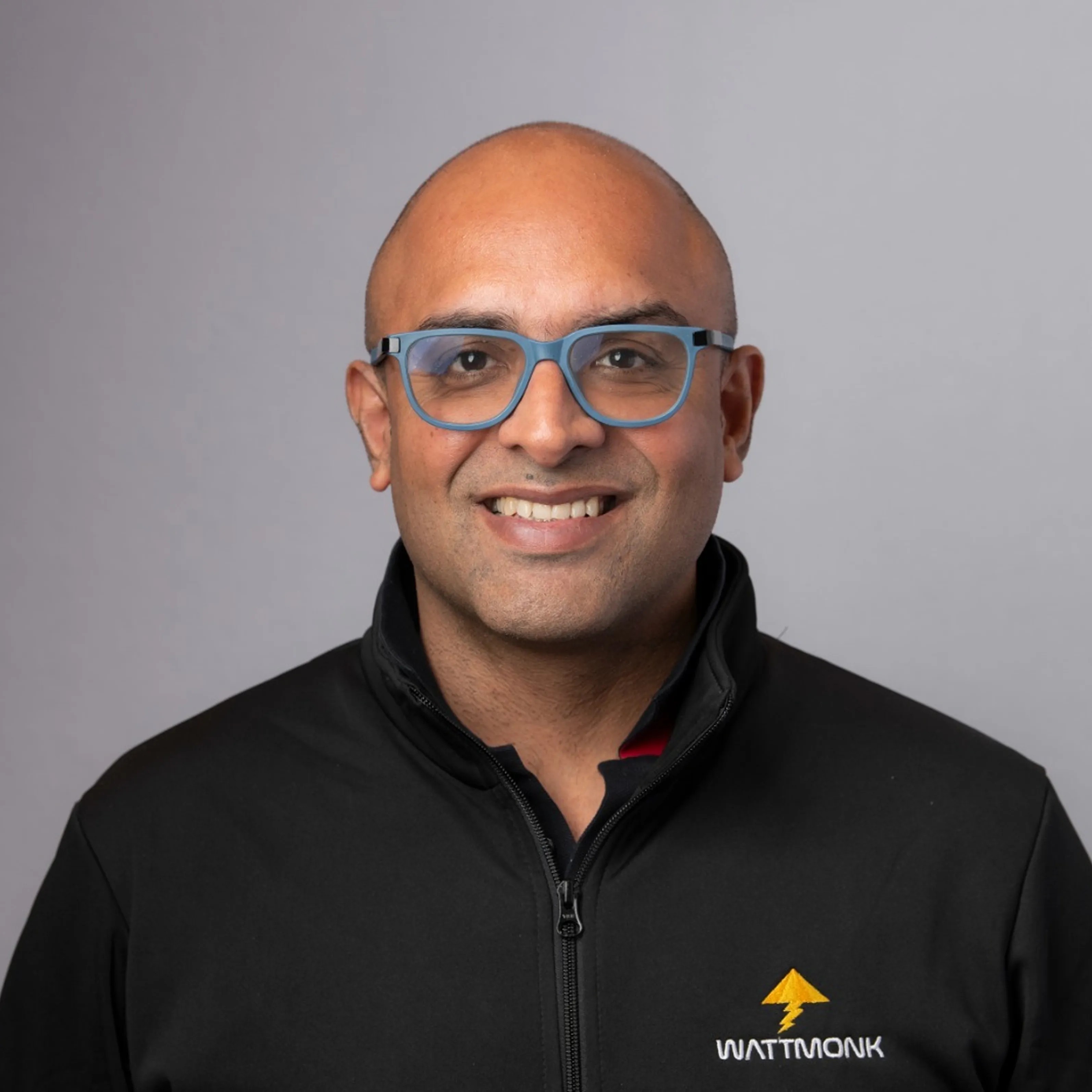 WattMonk founder and CEO Ankit Sheoran in blue glasses and a black company jacket