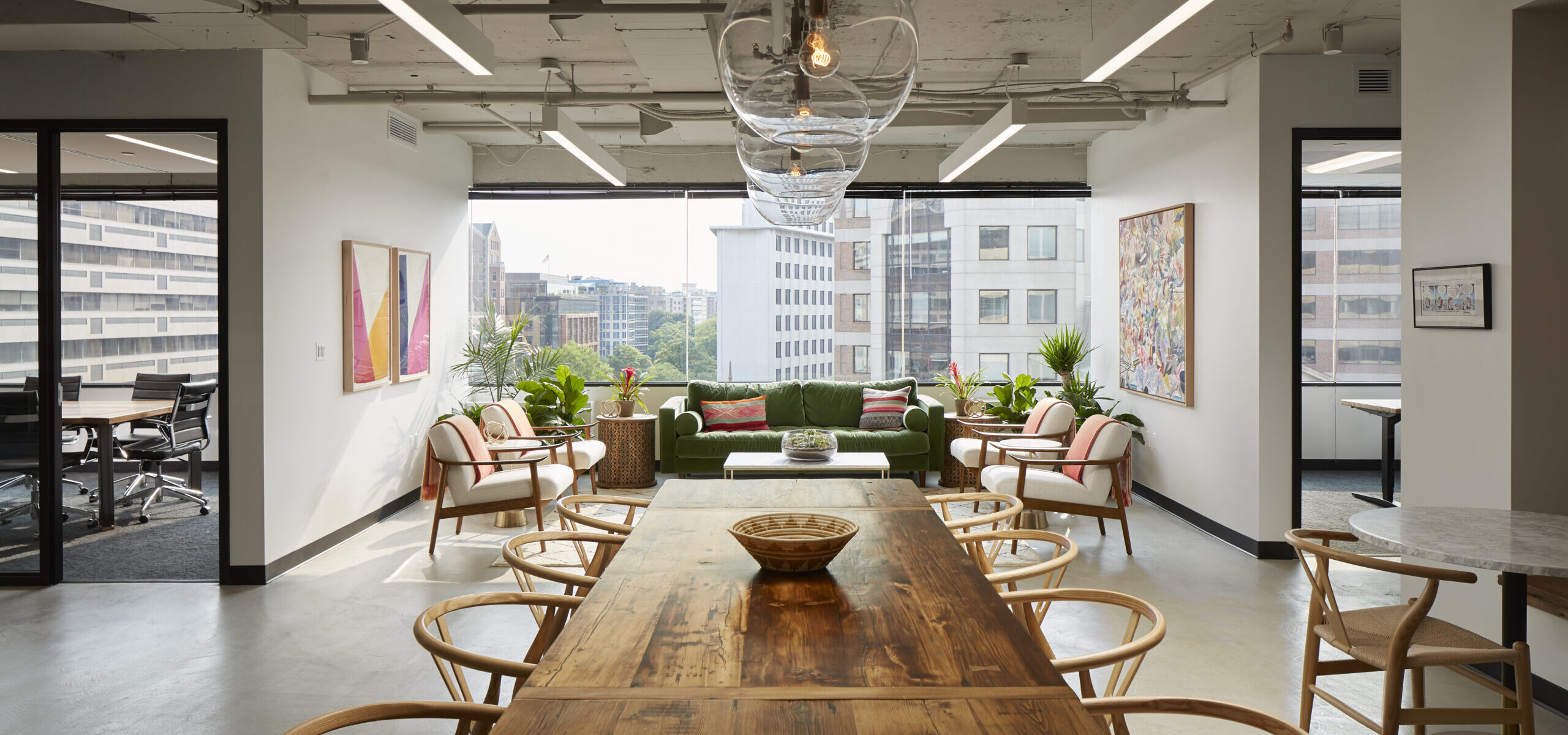 Waxman Strategies office lounge in Washington with a long wooden table and green sofa