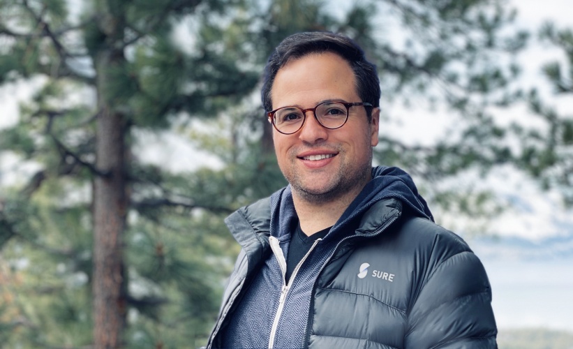 Wayne Slavin wearing glasses and a Sure jacket, photographed outdoors