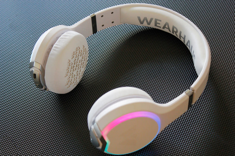 A white Wearhaus Arc headphone with a multicolor illuminated ring on one earcup