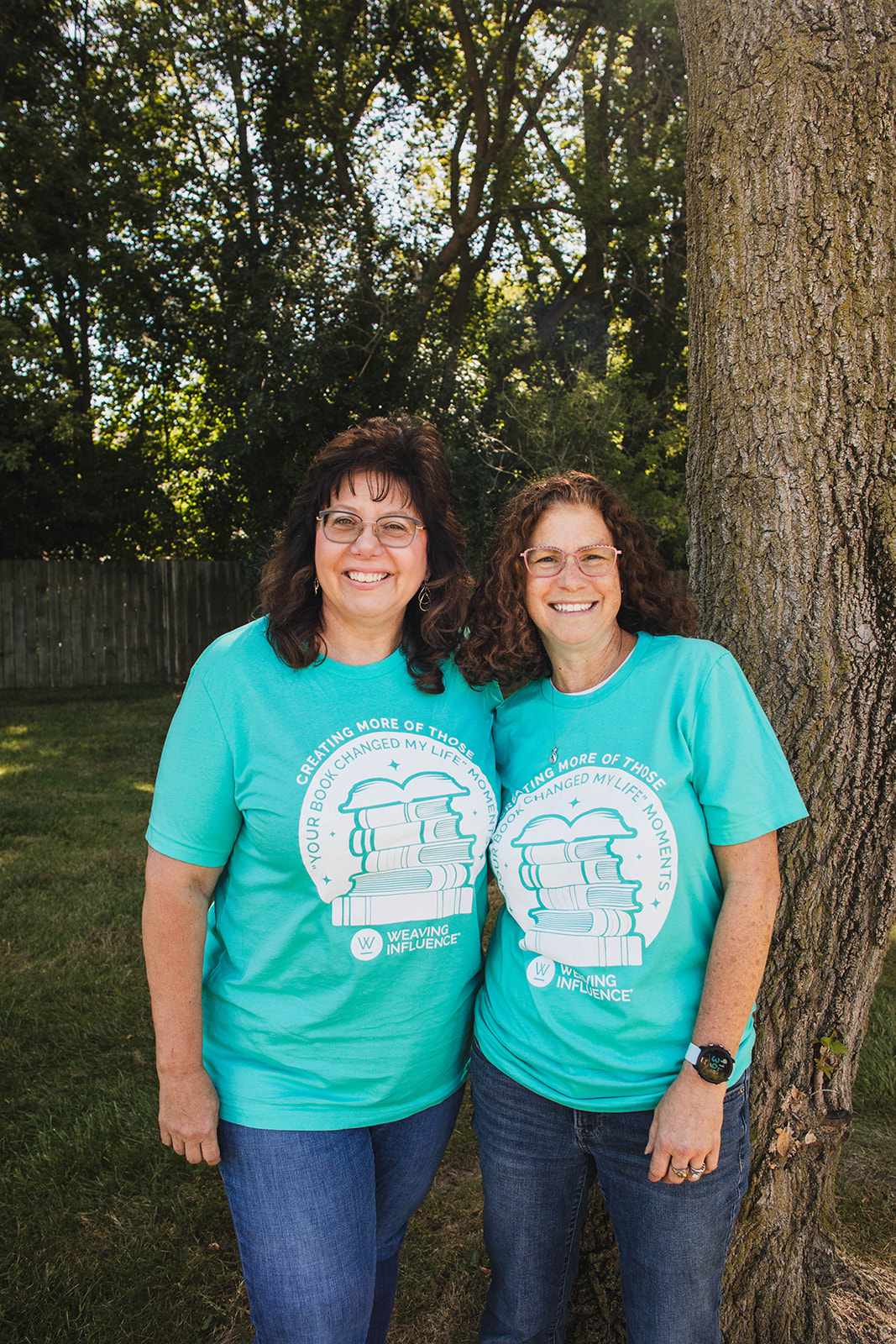 Two Weaving Influence team members wearing matching book-themed shirts