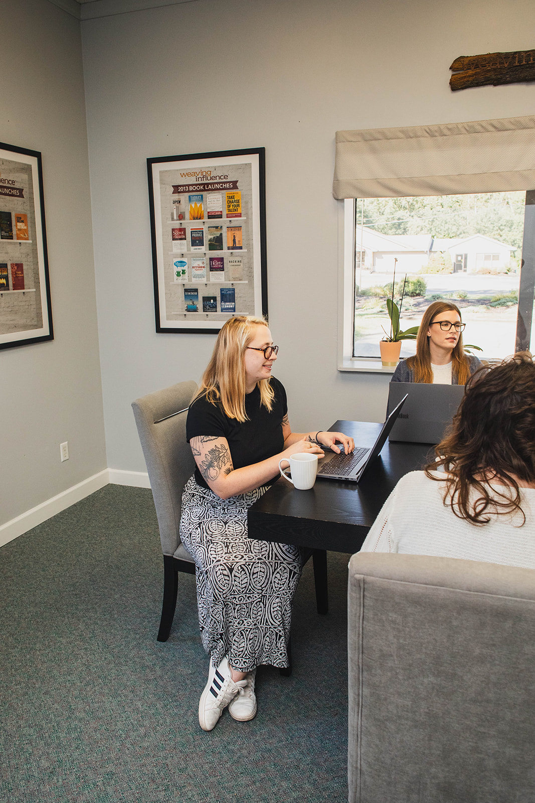 Members of the Weaving Influence team working around a table in the Lambertville office