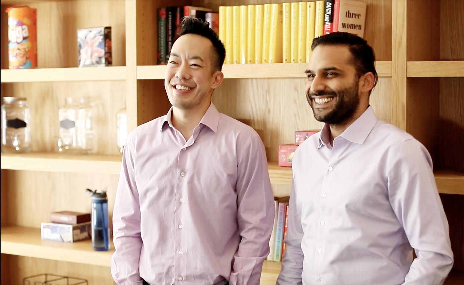 Web Sun, left, and Arif Nathoo standing together in front of bookshelves