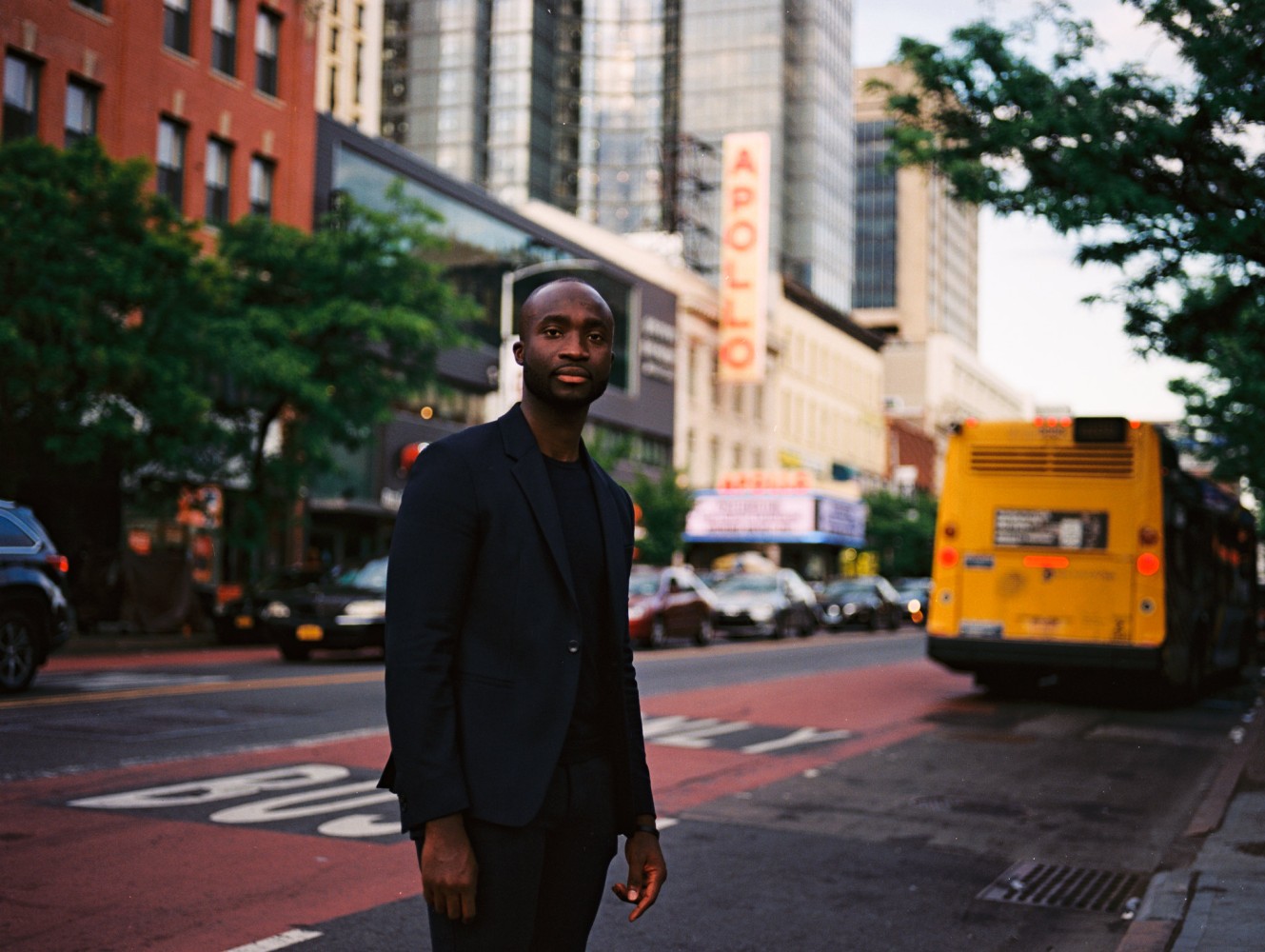 Wemimo Abbey standing on a Harlem street near the Apollo Theater in 2021