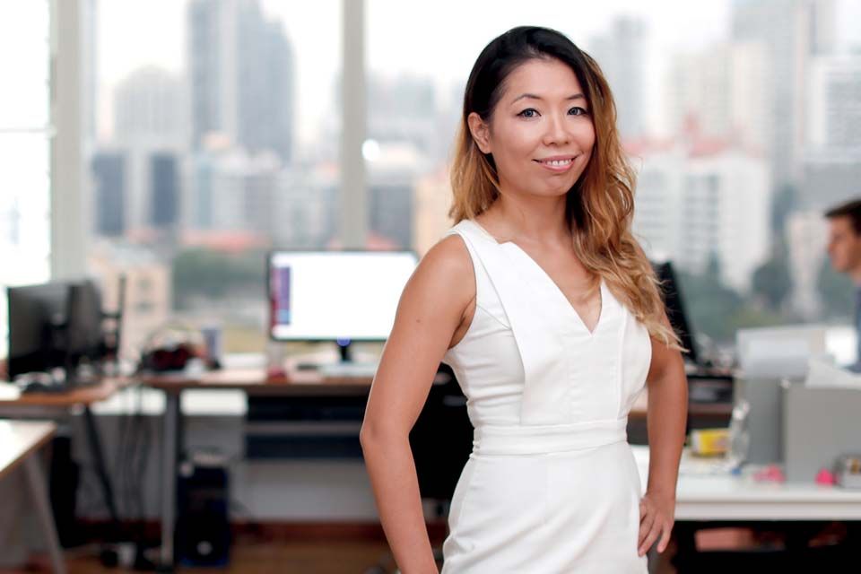 Wendy Chen in an office with workstations and windows behind her