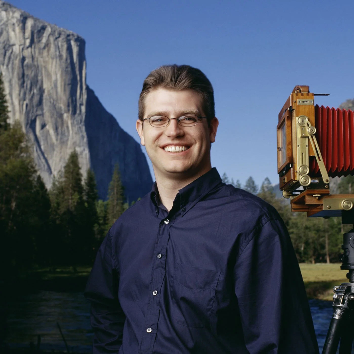 Rich Seiling beside a large-format camera with Yosemite cliffs behind him