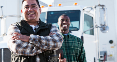 Two men standing beside a truck in Fleet One’s product marketing photograph