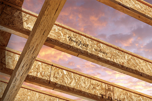 Weyerhaeuser TJI engineered joists crossing an unfinished building frame against a sunset