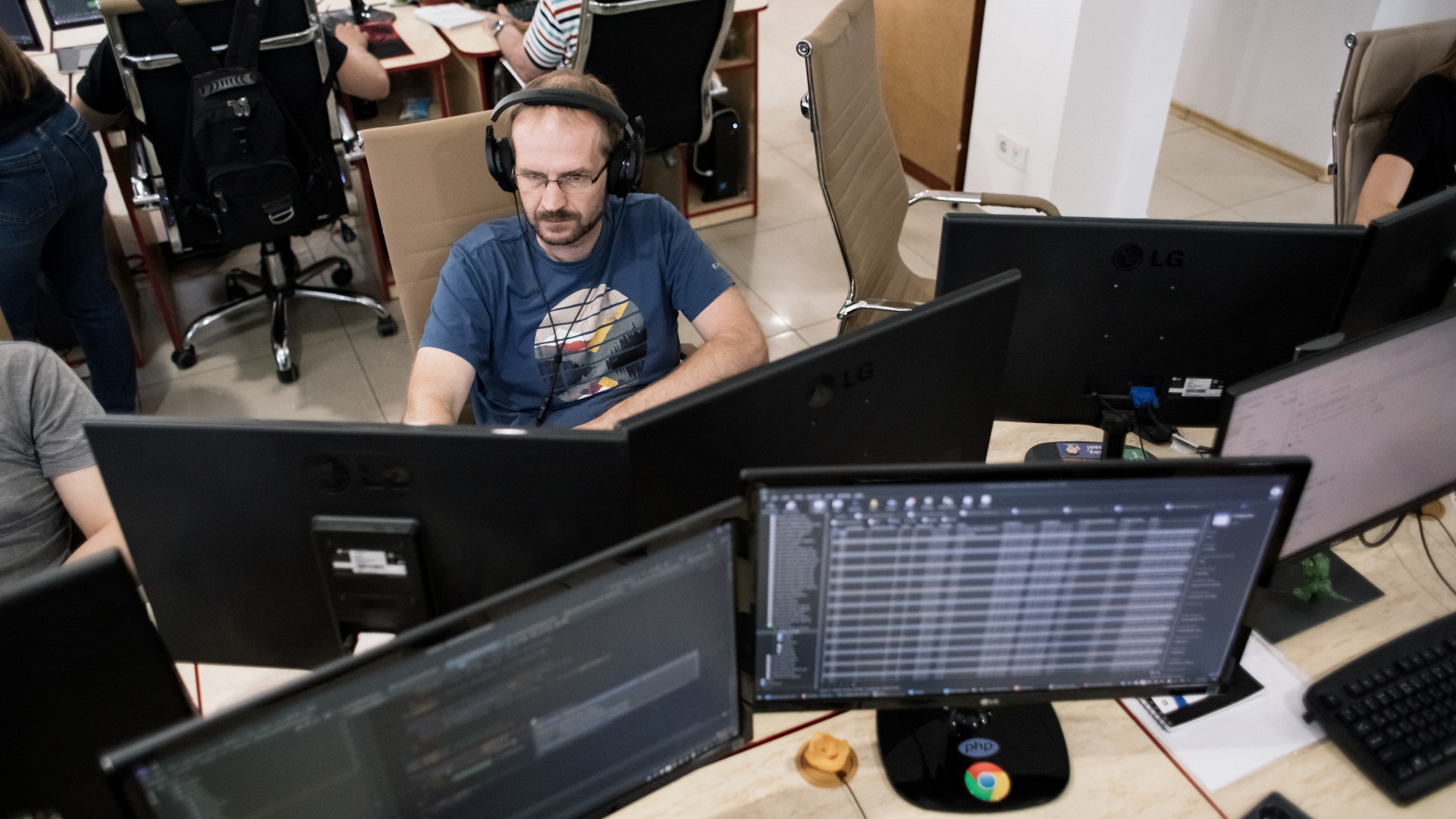 WEZOM employees working among several monitors in an office