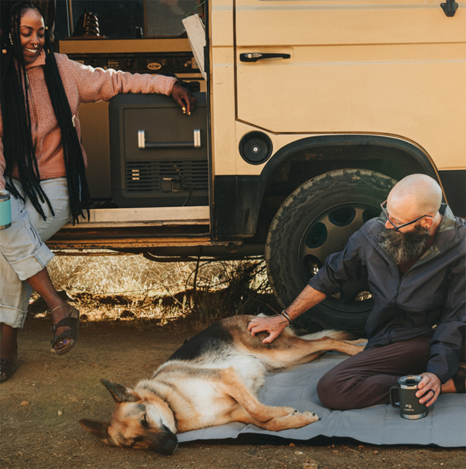 Two people and a dog relaxing beside an off-road vehicle during a Dometic campaign shoot
