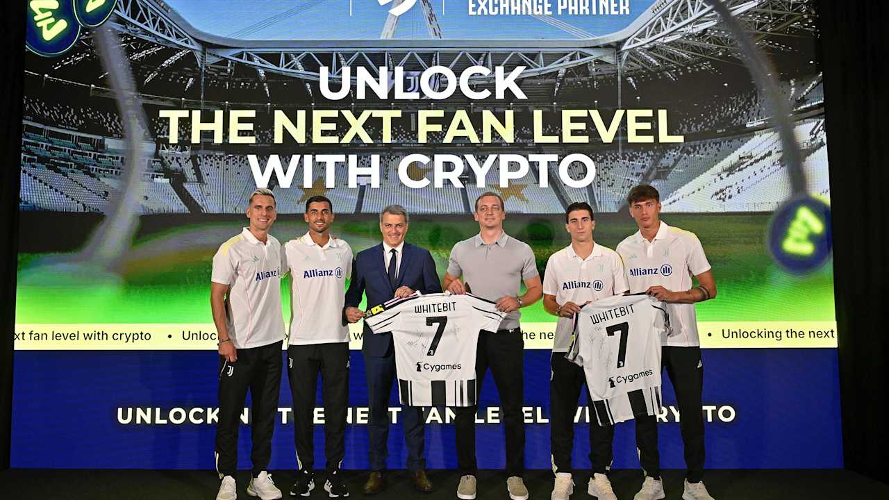 Juventus players and WhiteBIT representatives holding football shirts at the partnership event