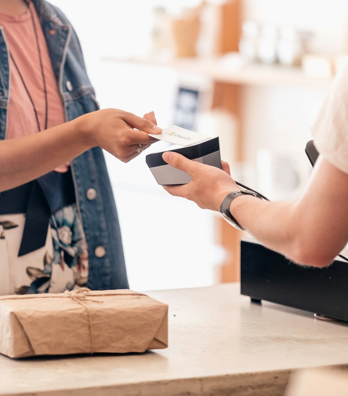 Illustrative photograph of a shopper paying by card at a checkout