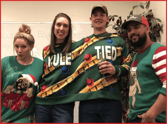 Members of the WickedThink team wearing holiday sweaters at an office gathering