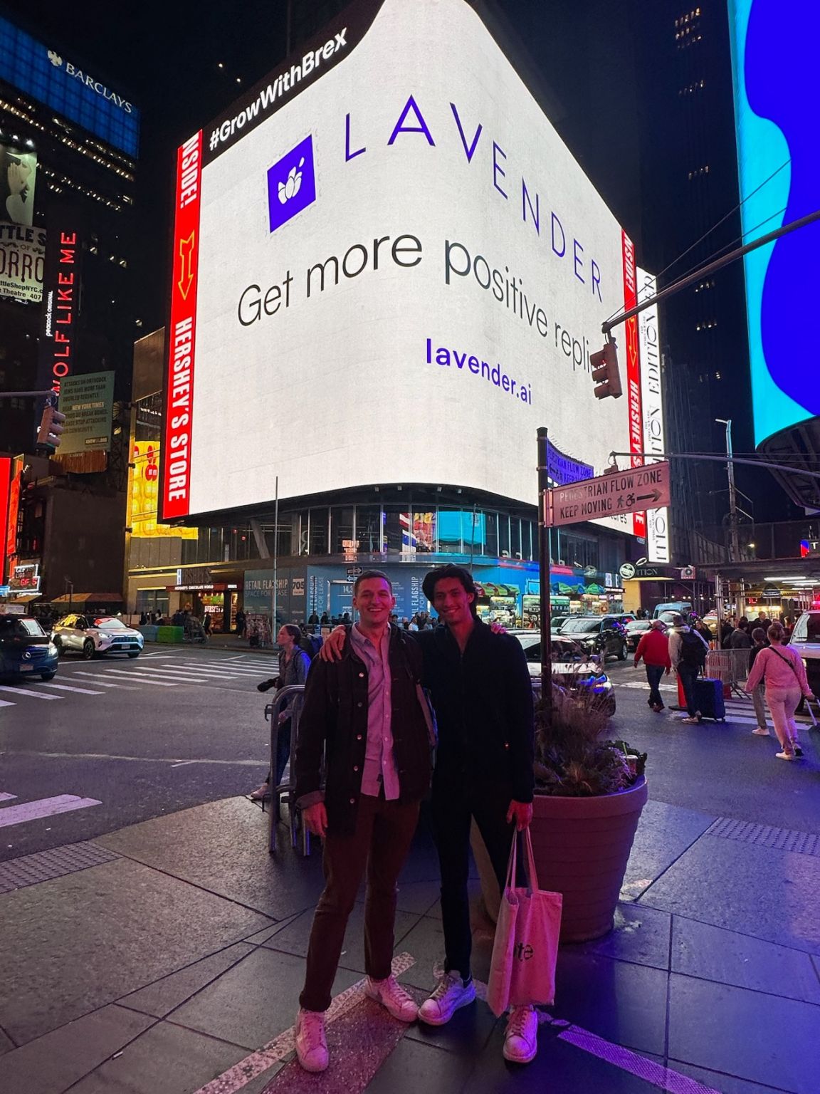 Two people beneath a Lavender billboard in Times Square at night, in a photograph shared by William Ballance