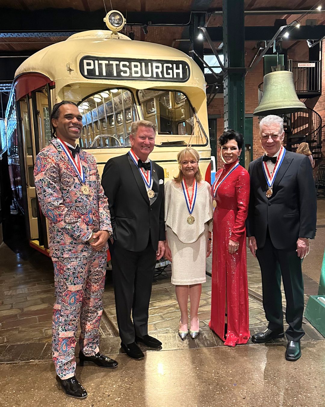 The five 2025 History Makers honorees stand beside a historic Pittsburgh streetcar; William Lambert is second from left.