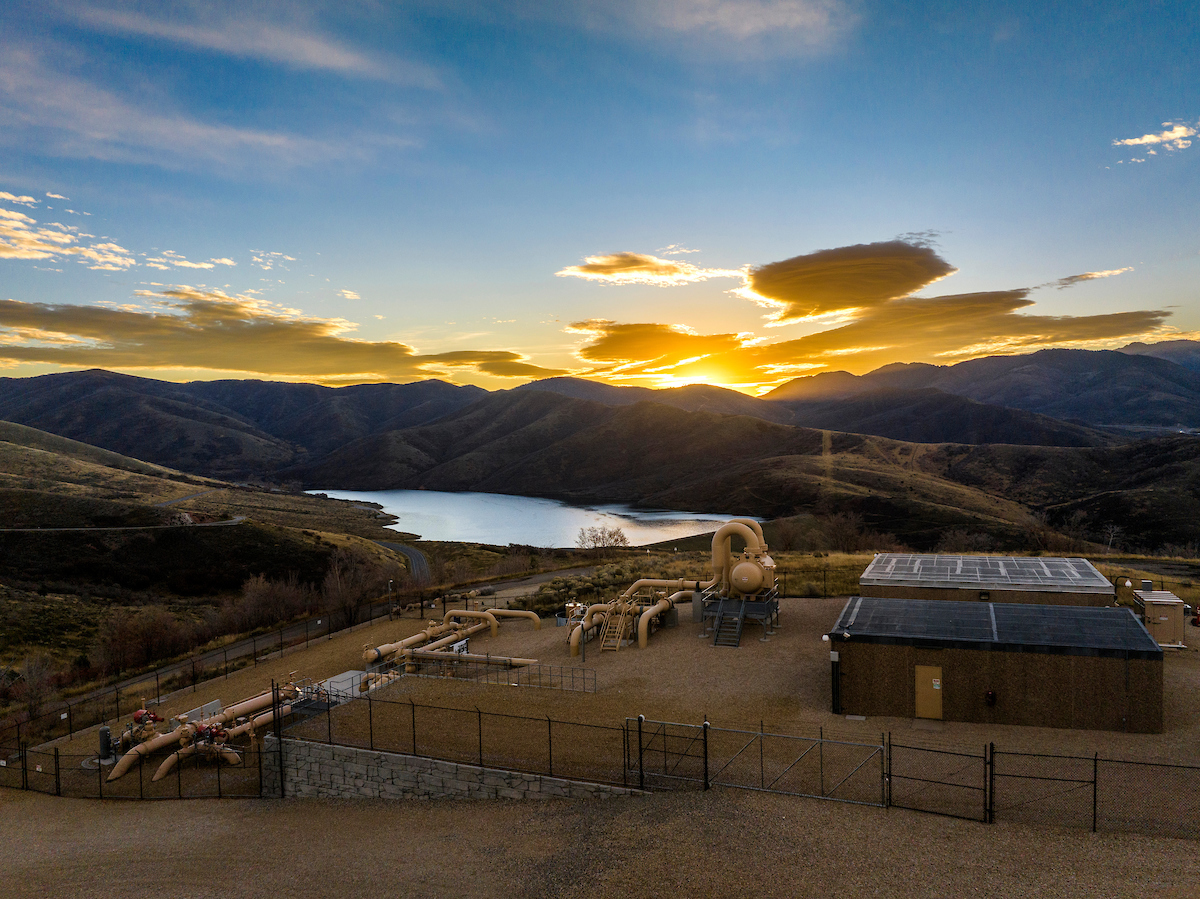 Williams gas infrastructure beside a reservoir and hills at sunset