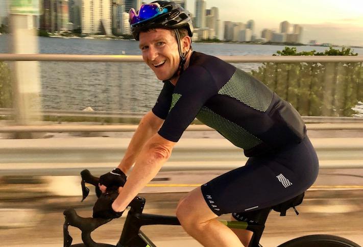 Willy Walker cycling outdoors in a helmet and cycling kit