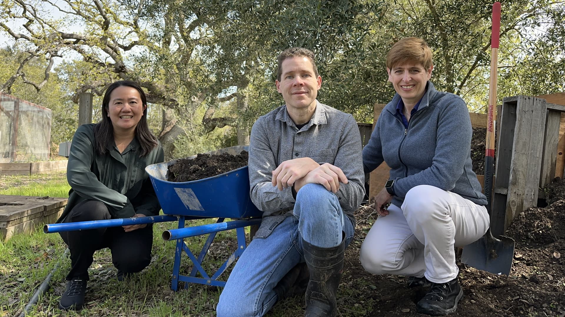 Judy Su, Josh Silverman and Carla Risso beside a wheelbarrow of soil
