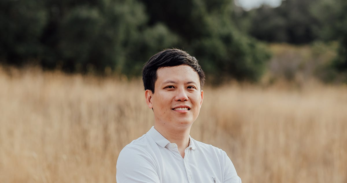 Winston Tang standing in a sunlit field