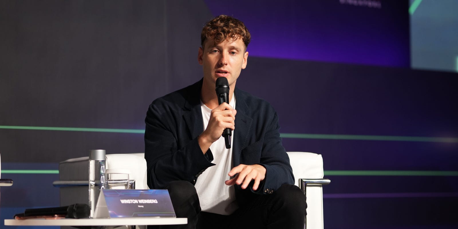 Winston Weinberg speaking into a microphone at TechLaw Fest in Singapore