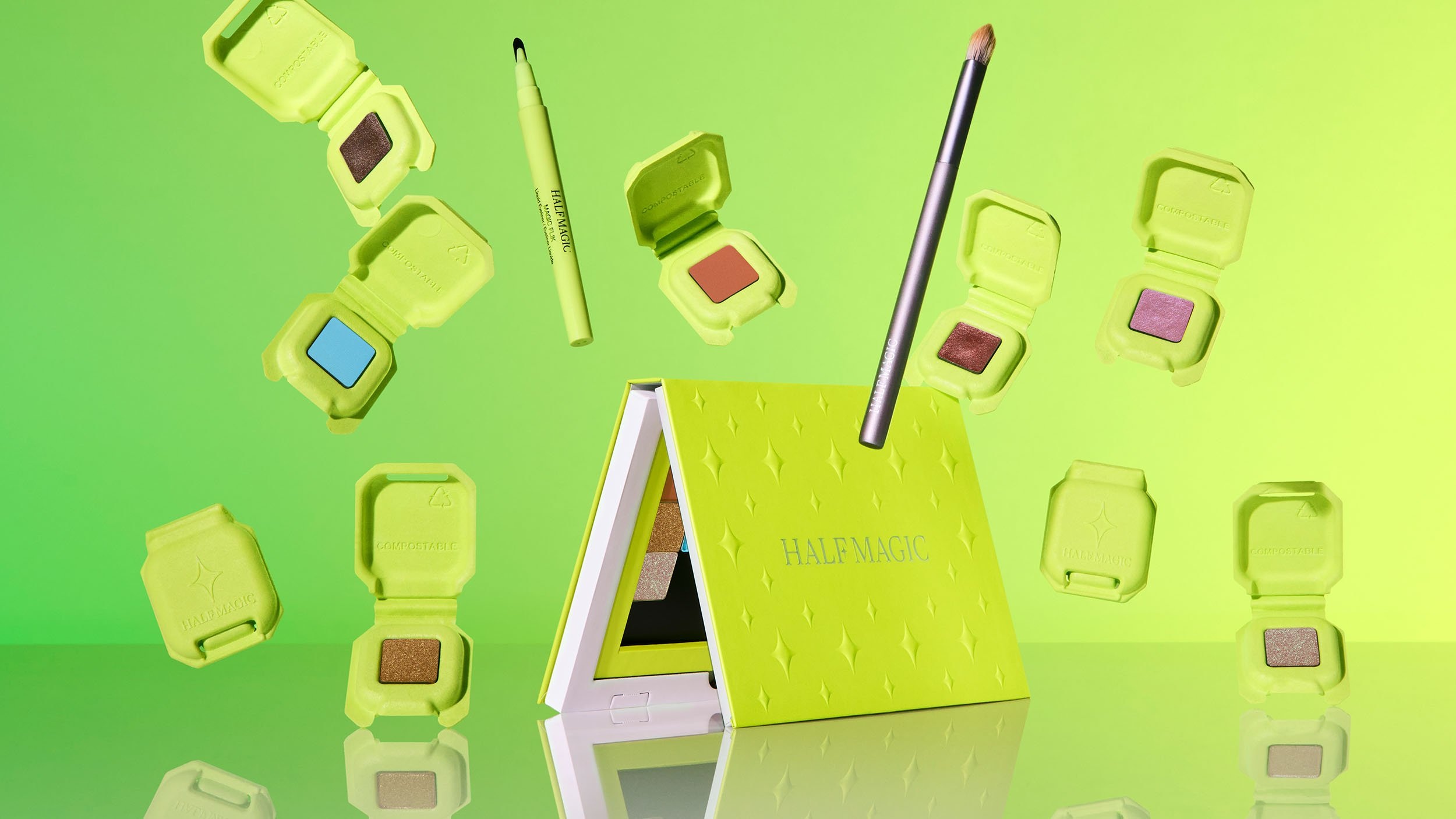 Half Magic green makeup packaging and palettes arranged against a vivid green background