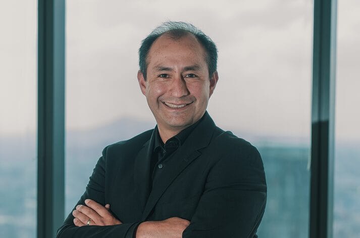 Wizeline founder Bismarck Lepe standing in front of tall office windows
