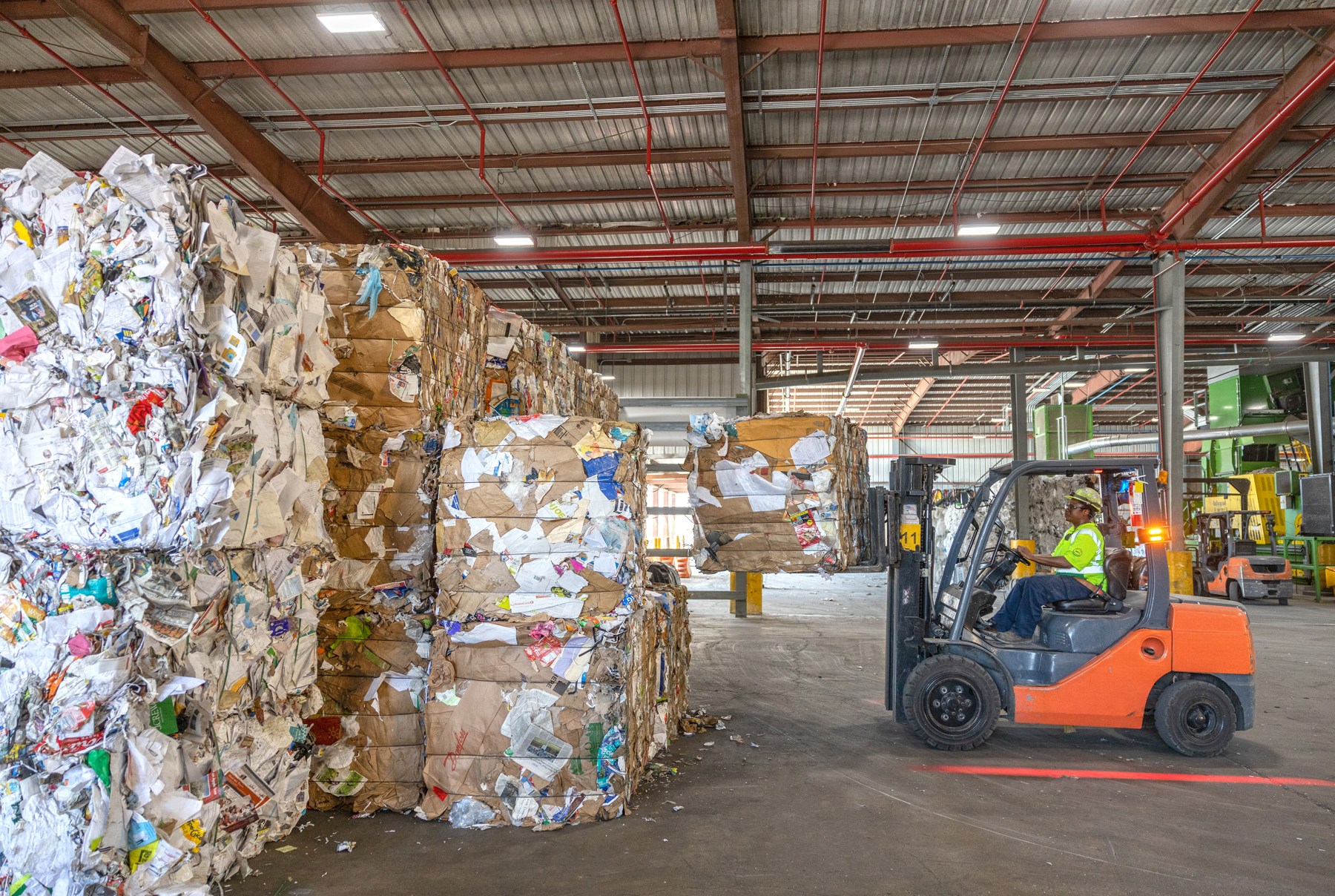 Bales of recovered material stacked inside a WM recycling facility