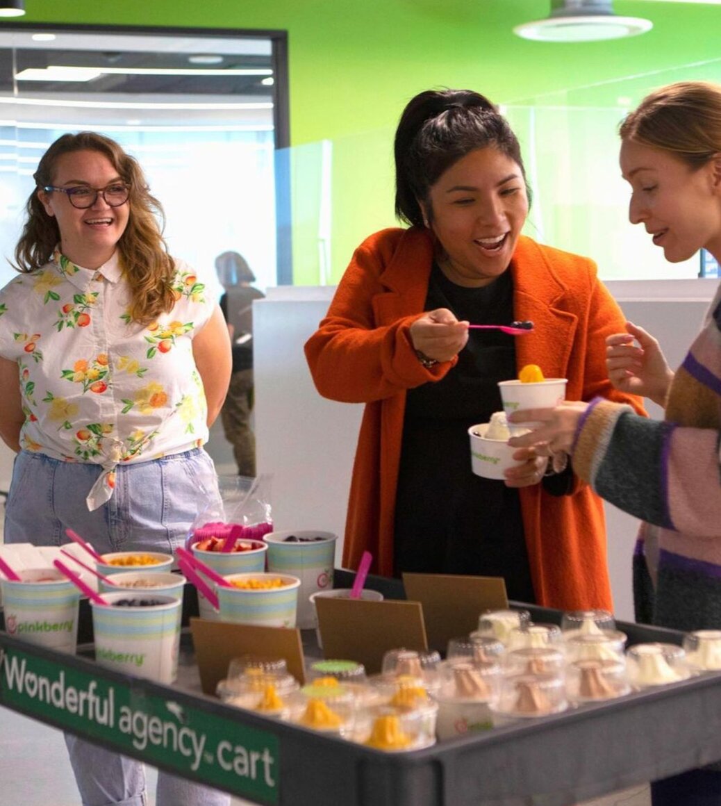 Wonderful Agency colleagues gathering around a frozen yogurt cart in the office