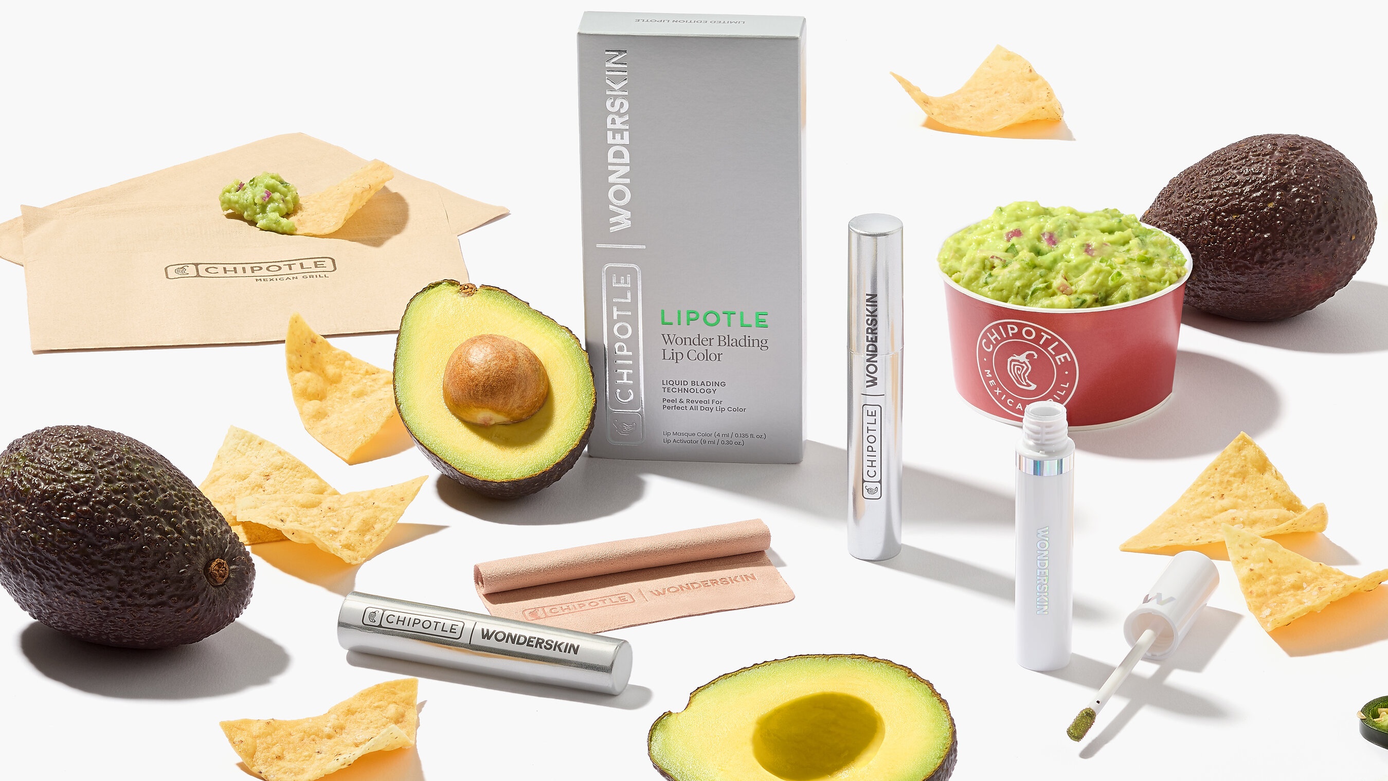 The silver Lipotle lip stain kit surrounded by Chipotle guacamole, avocados and tortilla chips
