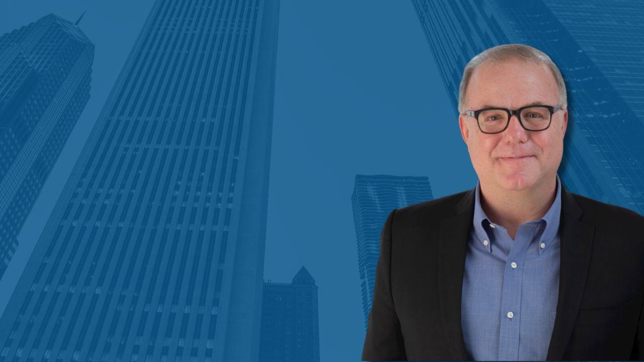 World Business Chicago president and CEO Phil Clement against a blue Chicago skyline backdrop