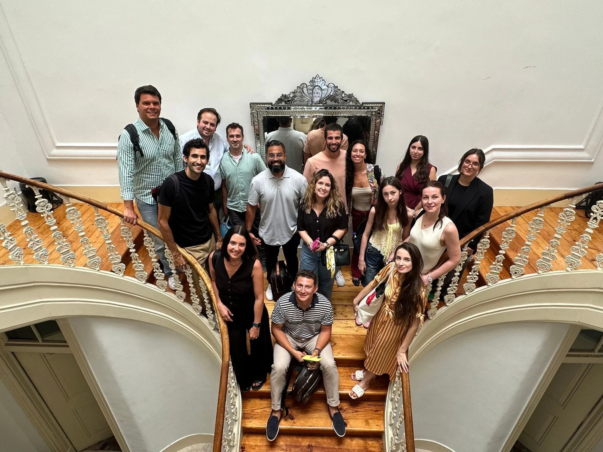 Members of the World Talents community gathered on a curved staircase