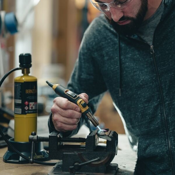 Maker using a Bernzomatic torch at a workbench