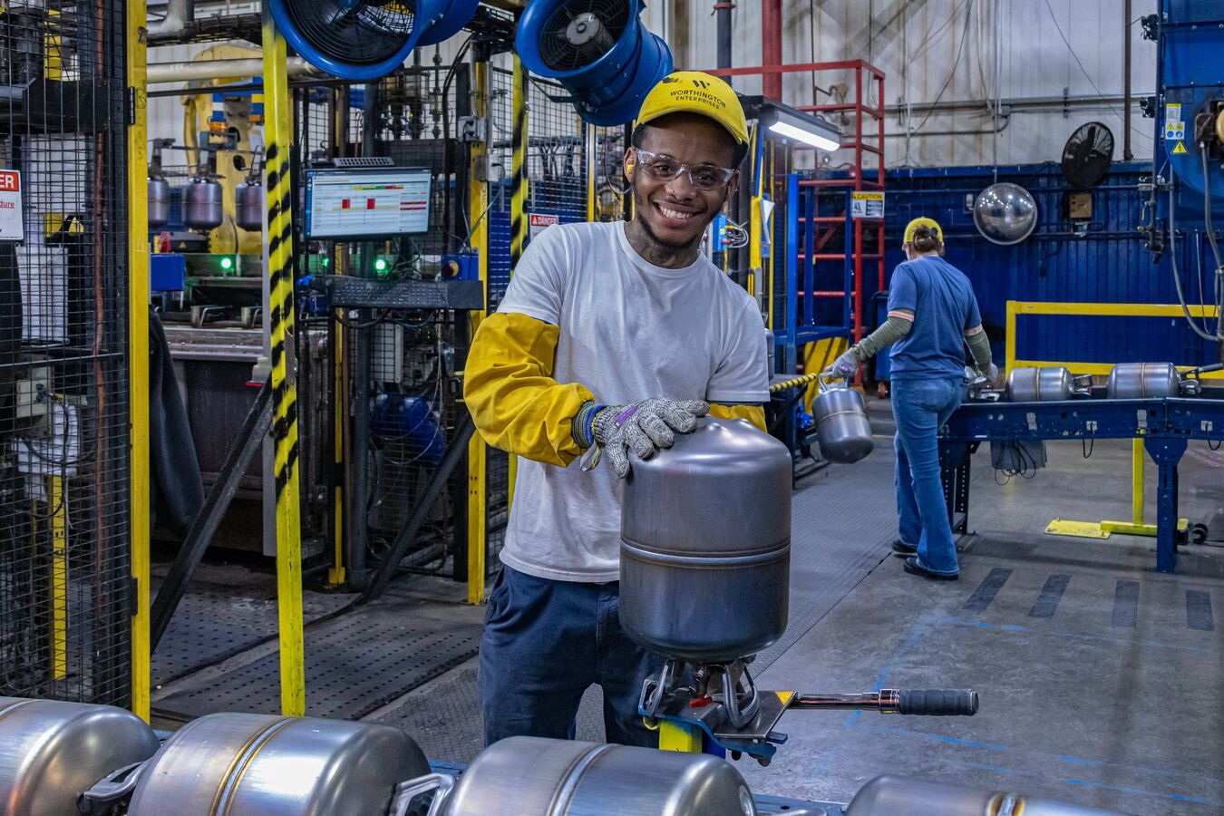 Worthington employee holding a cylinder on a Columbus manufacturing line