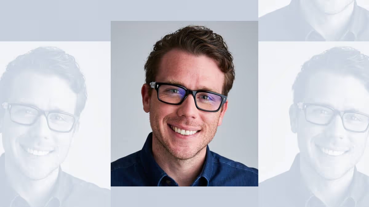Wrapbook co-founder Cameron Woodward wearing glasses and a blue shirt