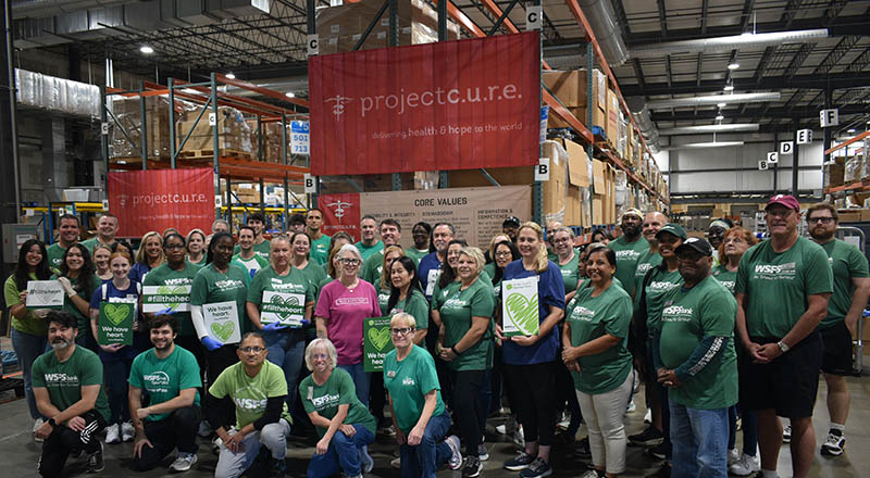 WSFS employees in green shirts gathered in a Project C.U.R.E. warehouse