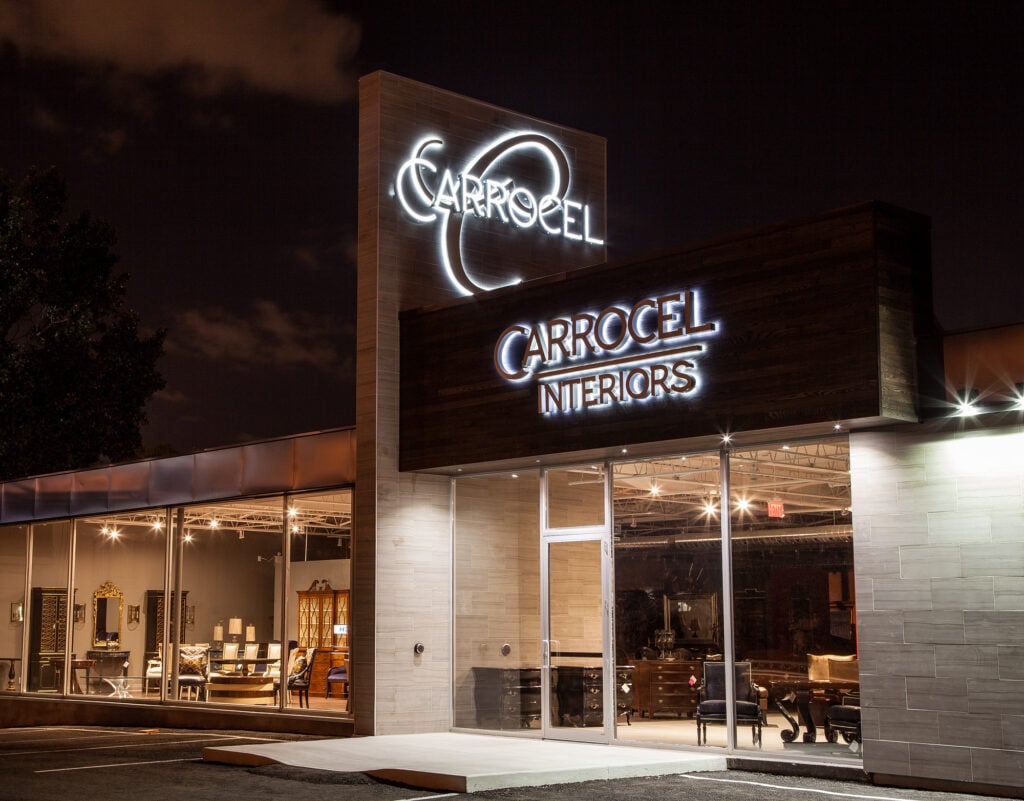 Illuminated Carrocel Interiors showroom facade at night