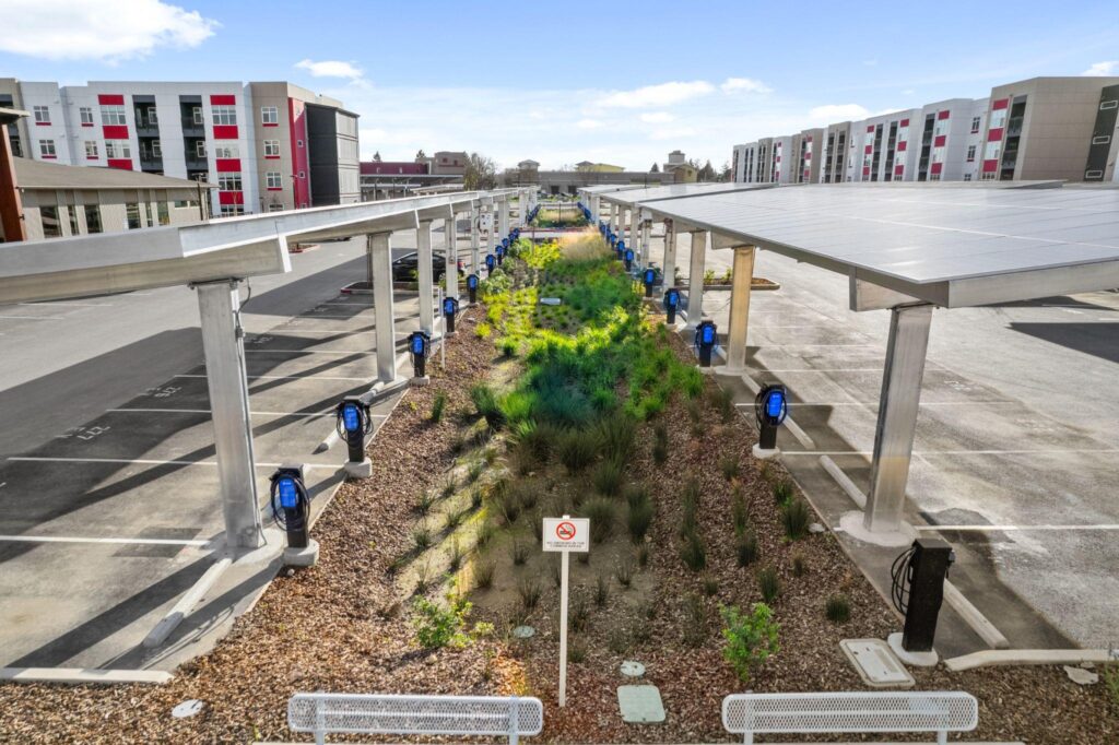 Rows of Xeal charging stations beneath solar canopies at a large residential property