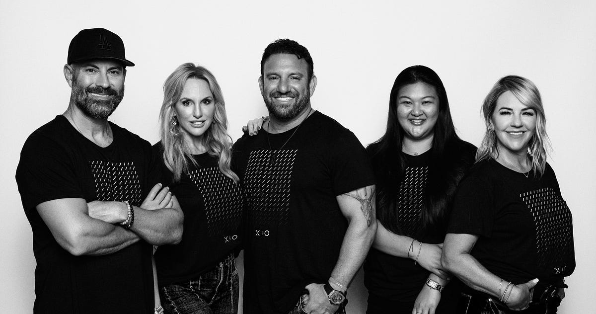 Five members of the early Xfactor.io team wearing matching black shirts